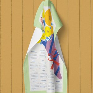 Colorful linen calendar towel hanging on a wooden wall