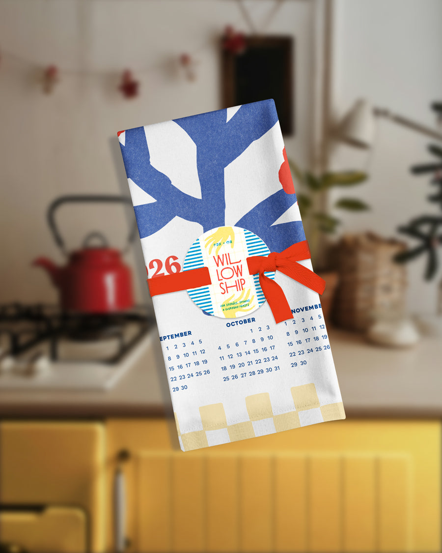 Folded tea towel with checkered border, tied with a simple ribbon for gifting.