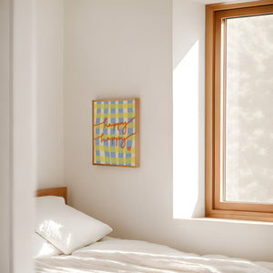Bedroom with a bed, colorful framed artwork on the wall, and a window.