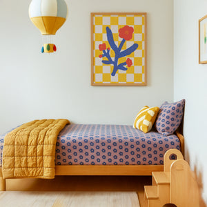 Children's bedroom with a bed, colorful bedding, and Willow Ship floral wall art.