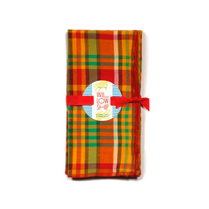 Merry Madras dinner napkins folded and tied with a red ribbon, finished with the Willow Ship round tag; ready for holiday gifting.
