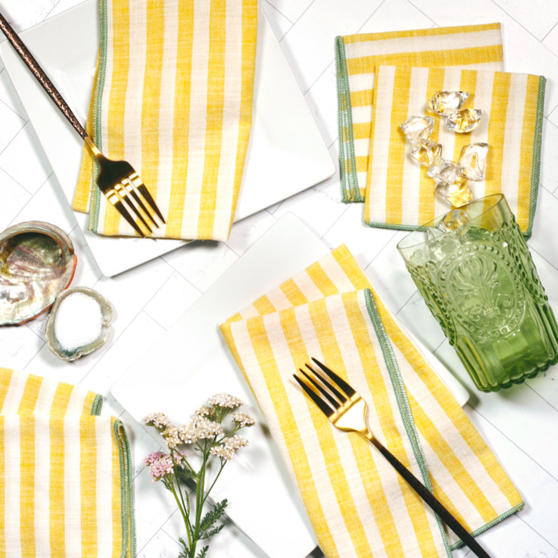 Cabana Citron striped napkins in summer table setting with drinks – yellow and cream cloth napkins with mint edge